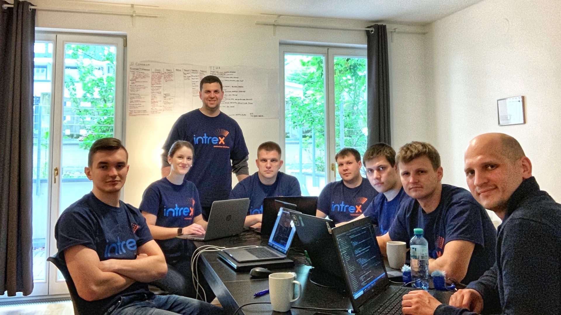 Intrex team sitting at a table with computers