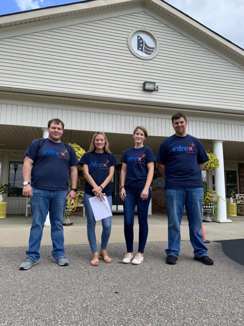 Intrex team smiling outside of a senior living community