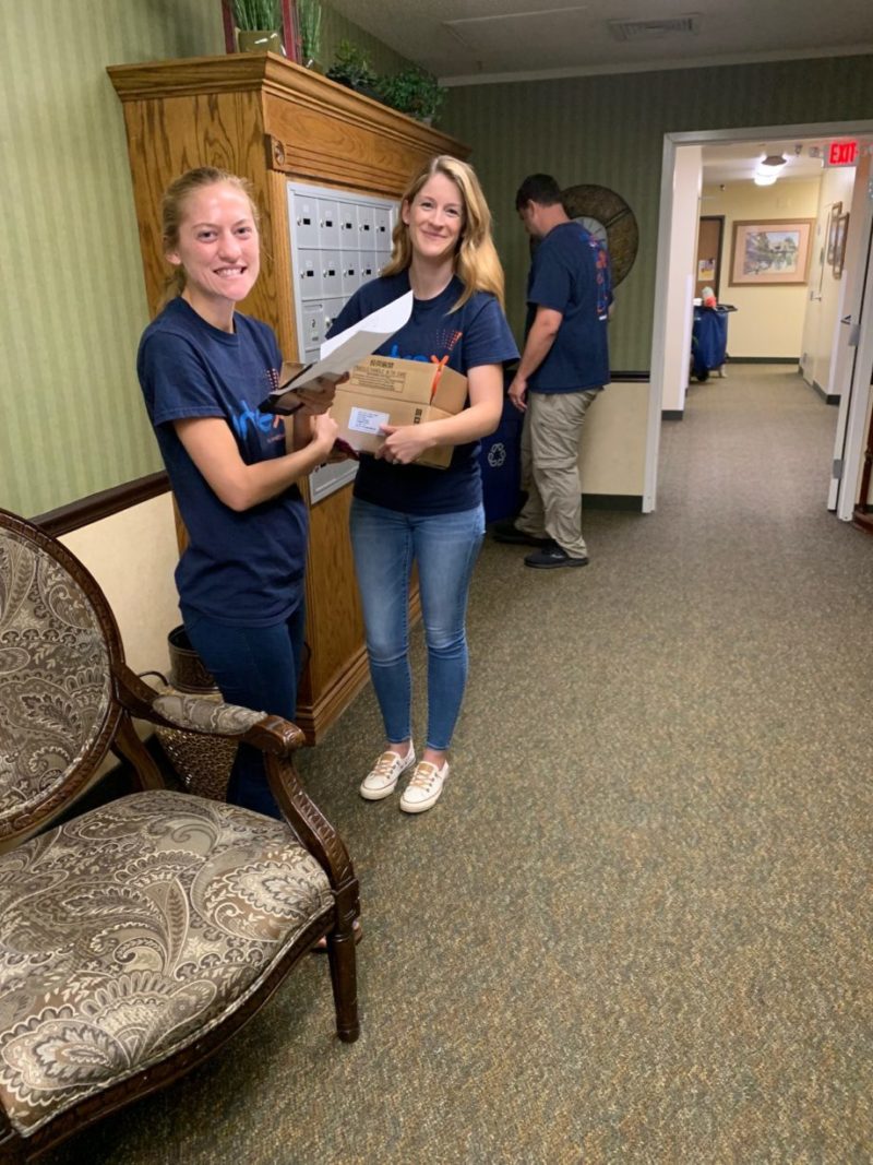 2 Intrex employees smiling while setting up wireless nurse call system